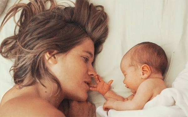 Frau liegend mit Baby